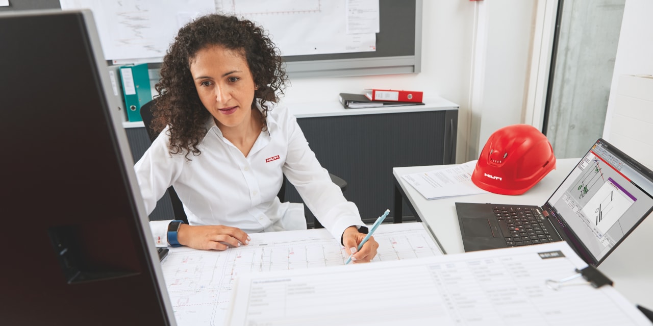 Hilti engineer onsite with a customer with shop drawings in the foreground